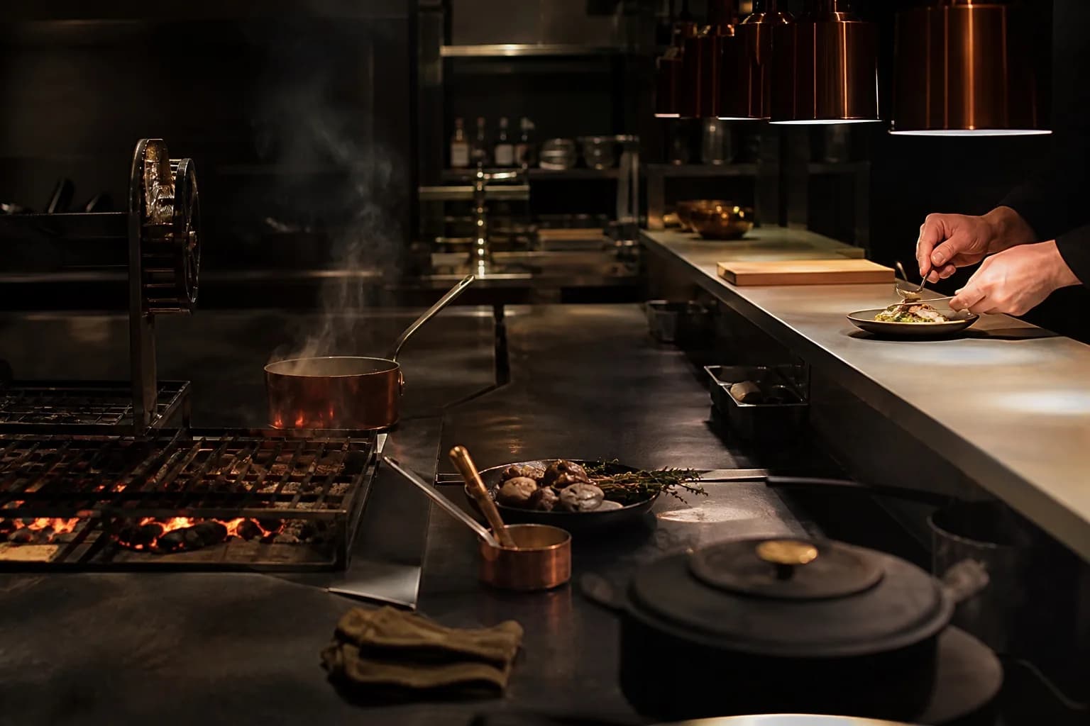 Cuisine ouverte VANTA avec un cuisinier dressant une assiette à la lumière du passe